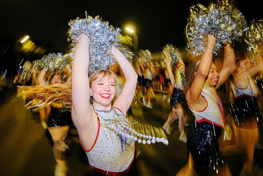 Cheerleaders raising their pompoms up 