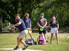 Students playing disc golf on campus.